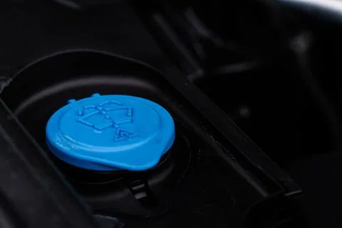Closeup blue windshield washer fluid reservoir cap in engine room. Liquid cap Stock Photos