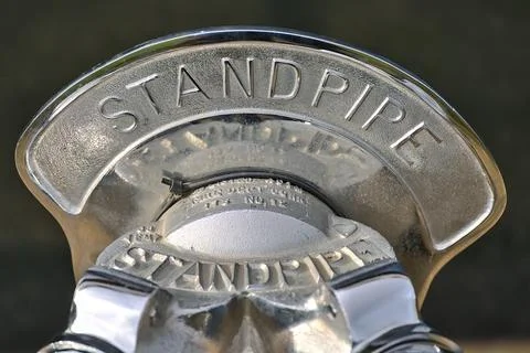Closeup blurry view of silver standpipe head with inscription, Dublin Stock Photos