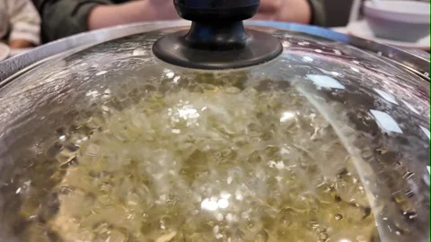 Closeup of boiling soup under glass pot lid Stock Footage 325650241
