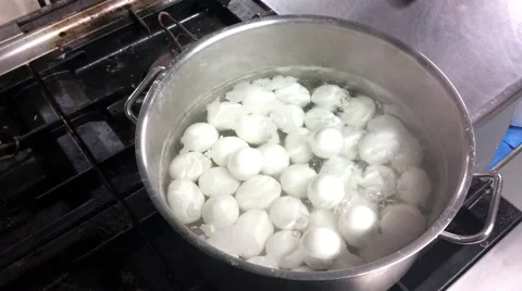 Closeup on boiling white chicken eggs, inside a pot, at a restaurant kitchen Stock Footage 57719024