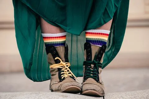Closeup of boots with pride socks under green formal dress Stock Photos