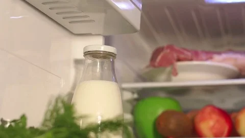 Closeup of bottle of milk on shelf in refrigerator Stock Footage 80243818