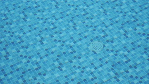 Closeup of the bottom drain of a swimming pool with the water moving through the Stockbeeldmateriaal 199474645