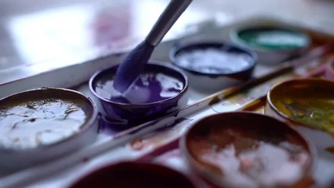 Closeup box of diffirents colors paint. Brush dipped in paint. Artist, stutent Stock Footage 70637849