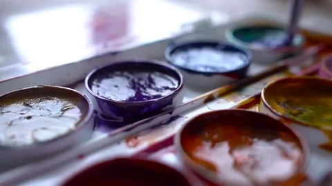 Closeup box of diffirents colors paint. Brush dipped in paint. Artist, stutent Stock Footage 70638194