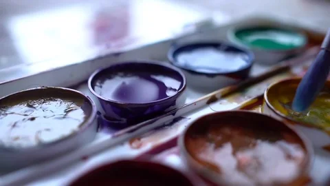 Closeup box of diffirents colors paint. Brush dipped in paint. Artist, stutent Stock Footage 70638781