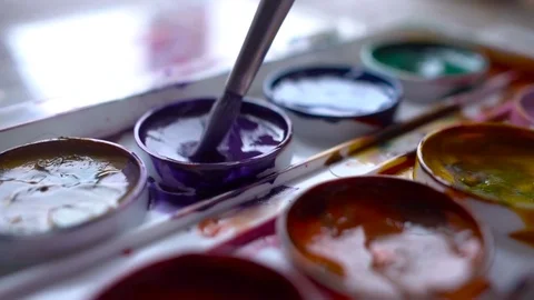 Closeup box of diffirents colors paint. Brush dipped in paint. Artist, stutent Stock Footage 70639278