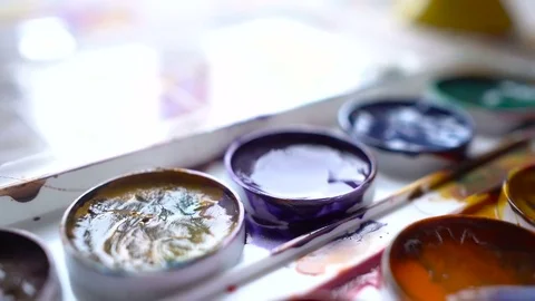Closeup box of diffirents colors paint. Brush dipped in paint. Artist, stutent Stock Footage 70639309