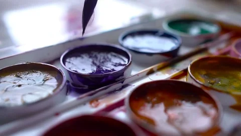 Closeup box of diffirents colors paint. Brush dipped in paint. Artist, stutent Stock Footage 70639379
