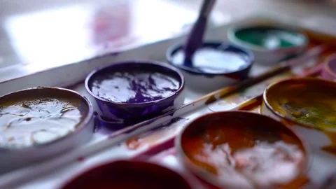 Closeup box of diffirents colors paint. Brush dipped in paint. Artist, stutent Stock Footage 70639405
