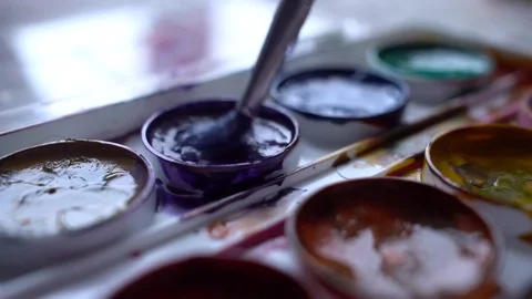 Closeup box of diffirents colors paint. Brush dipped in paint. Artist, stutent Stock Footage 70640735