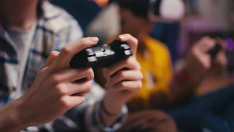 Closeup of boys in VR headsets playing vr video game with joysticks, modern tech Stock Footage 250335835