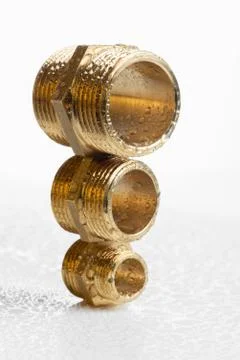 Closeup brass pipe fitting on white workshop table Stock Photos