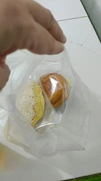 Closeup of bread and donuts in a small plastic bag Stock Photos