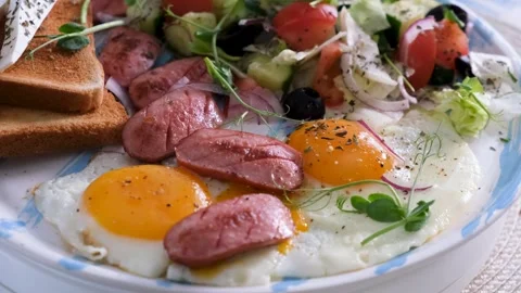 Closeup Breakfast Scene with Fried Eggs and Sausage Video Vídeos de archivo 332111202