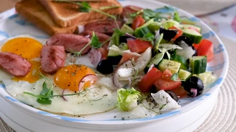 Closeup Breakfast Scene with Fried Eggs and Sausage Video Vídeos de archivo 332111209