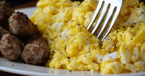 Closeup of Breakfast Scrambled Eggs and Sausage with Fork Stock Footage 114735692