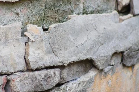 Closeup of brick wall with fallen plaster with selective focus on foreground Stock Photos