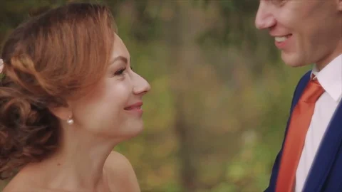 Closeup of bride and groom exchanging wedding rings over green nature background Stock Footage 80510568