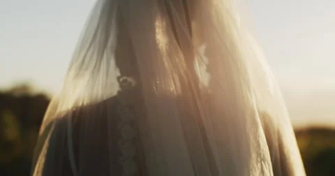 Closeup of brides veil as she walks during sunrise/sunset. Stock Footage 206600178