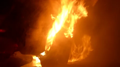 Closeup of bright flame burning in wheel compartment of a car at night Stock Footage 139114872