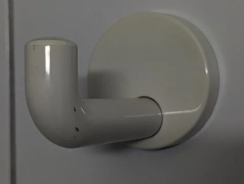 Closeup Of Bright Wall Hook With Soft Reflection. Modern Glossy White Wall .. 库存照片
