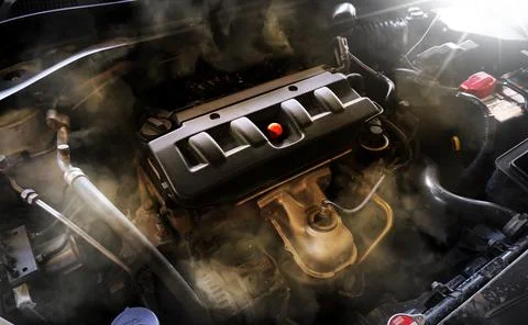 Closeup of a broken car engine with smoke coming out of the engine compartment Stock-Fotos