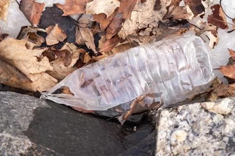 A closeup of a broken smashed and torn up ribbed clear plastic water bottle.. Stock Photos