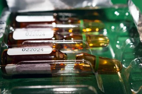 Closeup of Brown Empty Opened Glass Ampoule with White Label Best Before 2024 Stock Photos