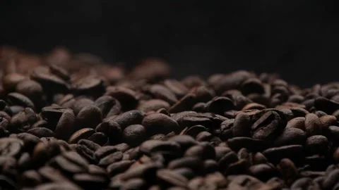 Closeup brown roasted coffee beans texture background with white steam or smoke Stock Footage 145180764