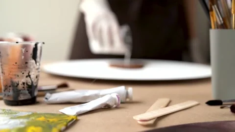 Closeup brushes, containers with mixed paints. Artist is creating picture, po Stock Footage 149304114