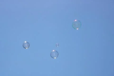 Closeup of bubbles floating in background of blue sky Stock Photos