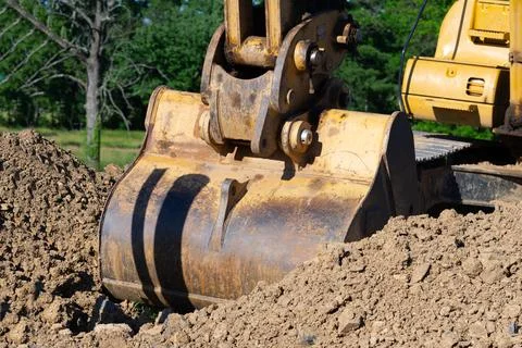 Closeup bucket of backhoe digging the soil at construction site crawler excav Stock Photos