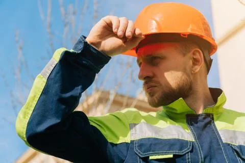 Closeup of a builder engineer holding a helmet with his hand. A man wants to  Stock Photos