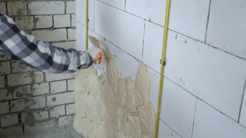 Closeup of builder putting plaster on aerated concrete block wall Stock Footage 102937315