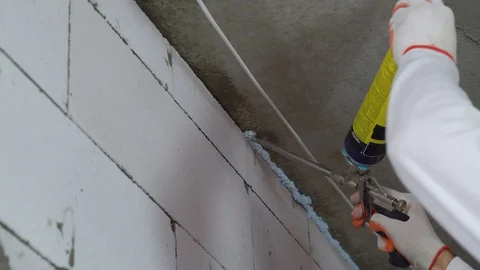Closeup of builder using mounting foam at construction site Stock Footage 102888150