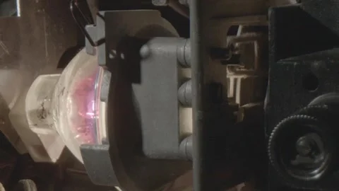 Closeup of the bulb of an 8mm projector that is on, shutter at 16 fps Stock Footage 256657096