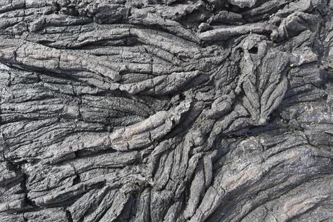 A closeup of the bumpy rough gray volcanic rock texture in the beach in Kailu Stockfoto's