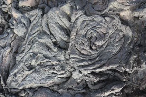 A closeup of the bumpy rough gray volcanic rock texture in the beach in Kailu Stock Photos