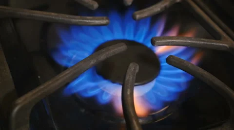 Closeup-Burner on black gas range ignites and burns with blue flame. Stock Footage 68898968