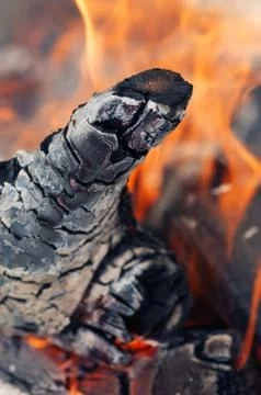 Closeup of burning log in an open fire and orange flame in background Stock Photos