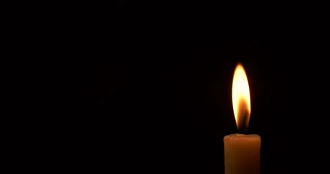 Closeup burning single candle flame isolated on black background with copy space Stock Footage 188654331