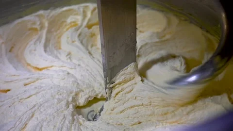Closeup of butter being whipped in large industrial mixer. Stock Footage 133726862