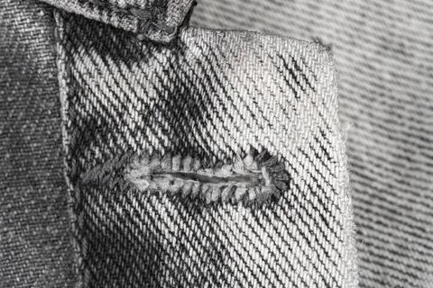 Closeup of buttonhole on grey denim jacket. Texture of cotton fabric with d.. Fotos Stock
