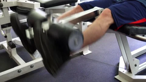 Closeup of the calves of a man lifting weights with his feet in the gym 動画素材 164588378