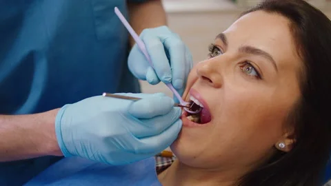 Closeup to the camera beautiful female have a oral care examination in a modern Stock Footage 156811348