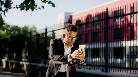 Closeup to the camera in the middle of the street guy with a electric scooter Stock Footage 138159068