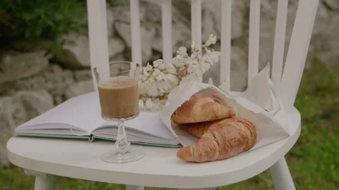 Closeup camera moving to black coffee in a glass and french croissant Stock Footage 233769286