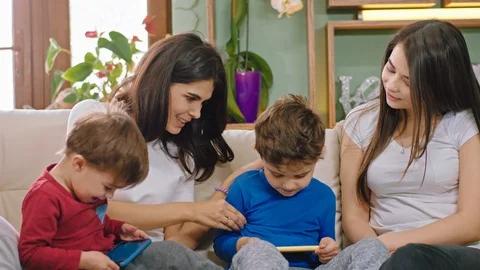 Closeup to the camera two mothers playing together with their kids two pretty Video stock 127704078