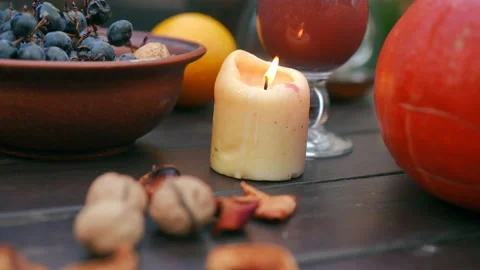 Closeup candle burning on table with dried fruits and smoothie outdoors. Calm Stock Footage 237517283